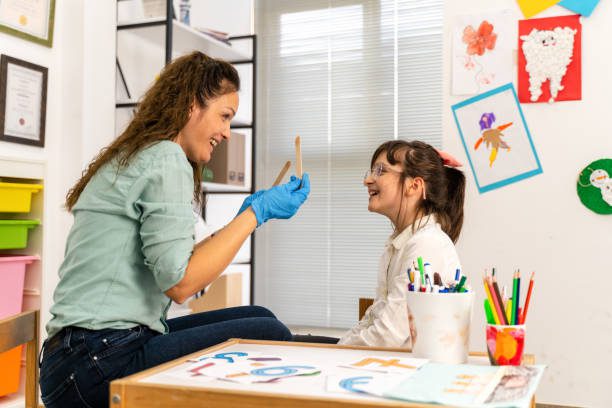speech therapist working with girl training pronunciation
